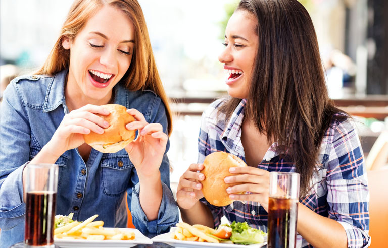 Girls eating cheeseburgers