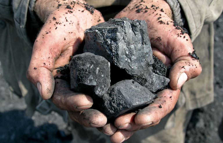Miner hands with coal