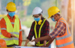 Workers in hard hats, masks