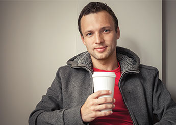 guy holding white cup