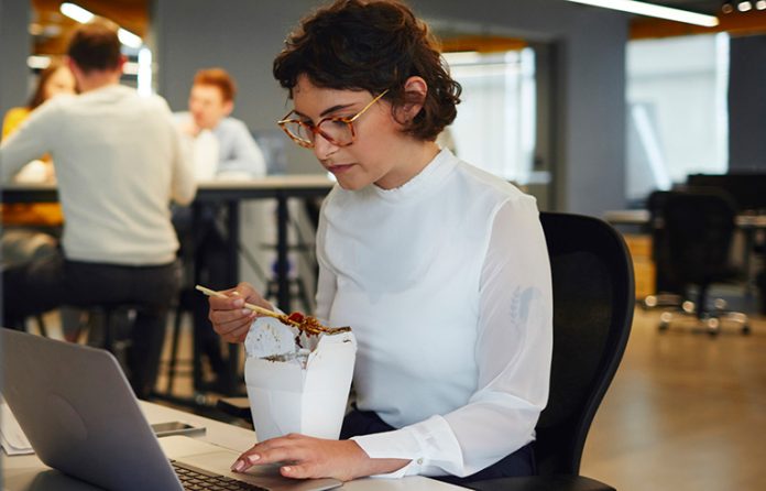 Millennial at desk eating