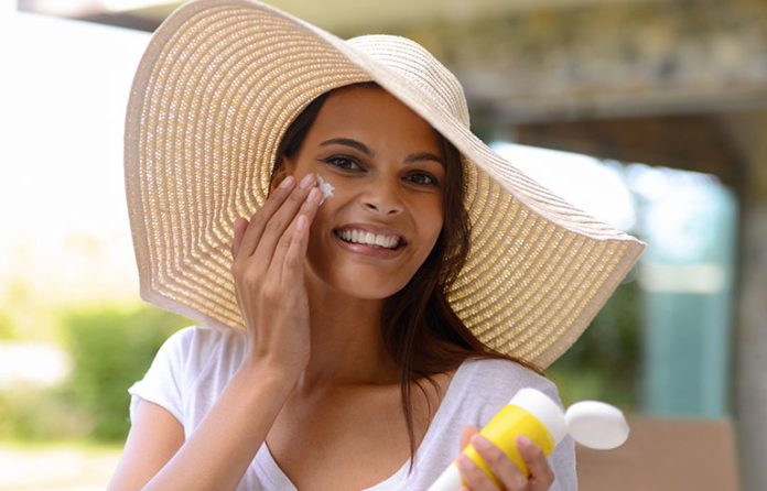 woman putting on sunscreen