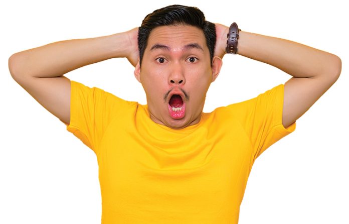 Asian man yellow shirt shocked face