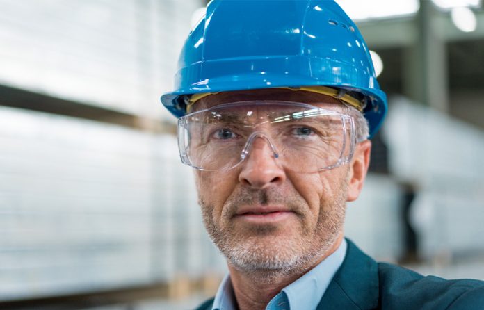 Business man in suit with hard hat and safety glasses