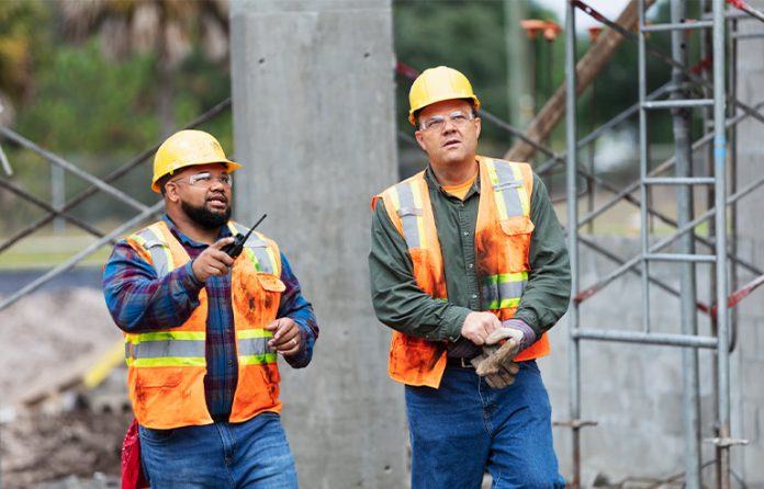 Two construction workers talking on jobsite