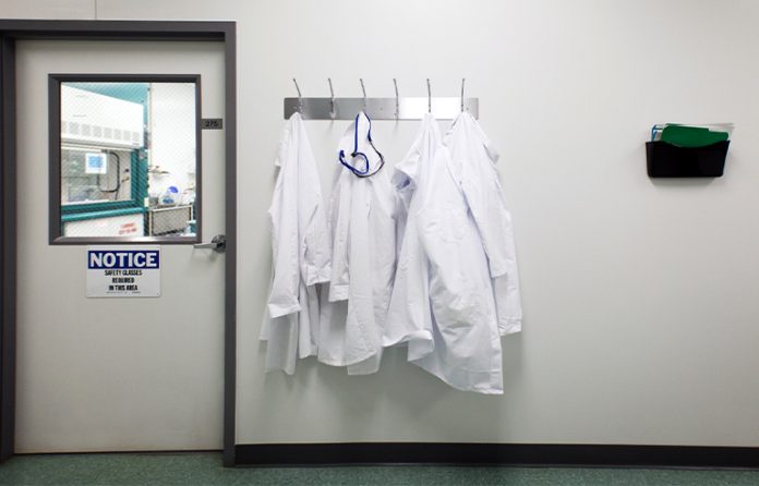 Laboratory white coats hanging outside lab door