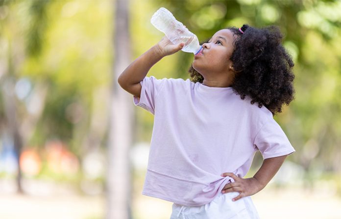 Little girl drinking from a water bottle